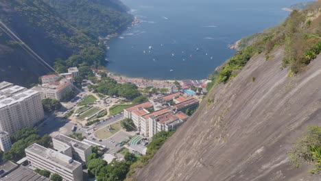 slow aerial pan over a mountain with red beach in the background in rio de janeiro brazil