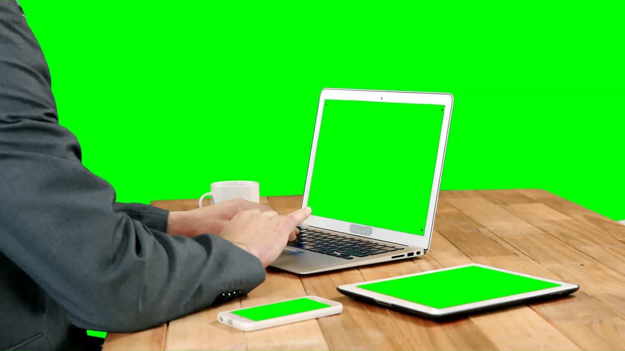 hombre de negocios tomando café mientras usa una computadora portátil