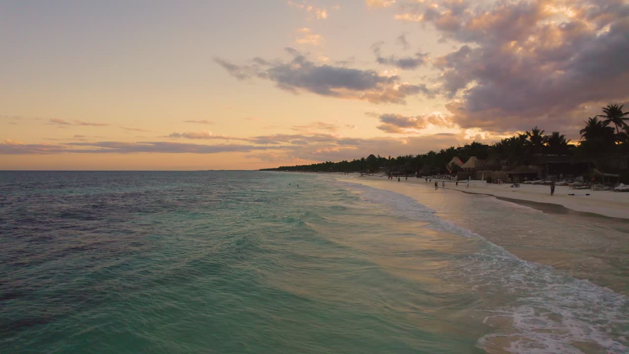 vista aérea cerca del océano caribe en la playa akiin en tulum, méxico durante la puesta de sol con gente disfrutando de sus vacaciones en la playa