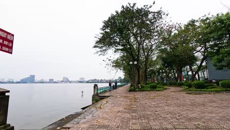 tranquil lakeside scene with trees and cityscape