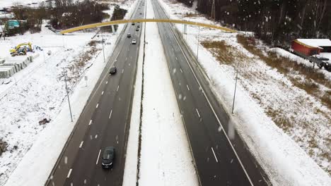 heavy snowfall over highway road in winter season, aerial descend view