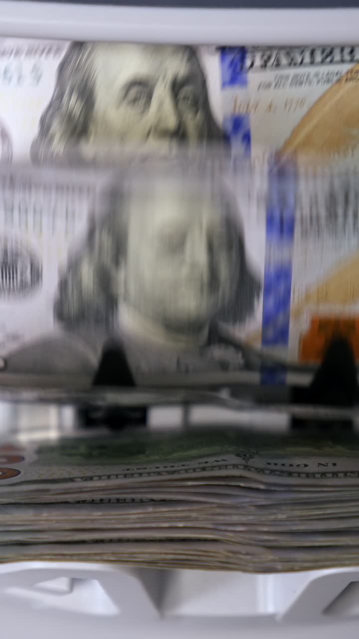 Money counting equipment for paper money calculation. Automatic mechanism for bank financial operations. Currency exchange of one hundred usd. Closeup currency counting machine counting dollar bills Vertical video