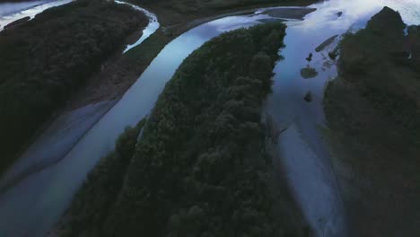 flying above river flowing into black sea against colourful sunset