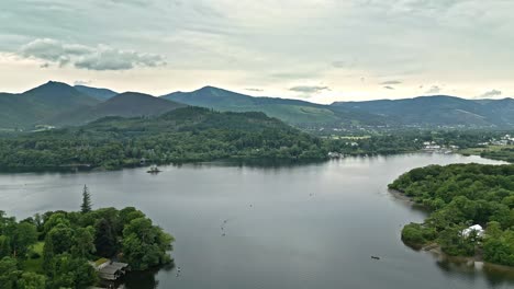 drone aerial footage of derwentwater, keswick, a calm lake with river boats and a stormy sky