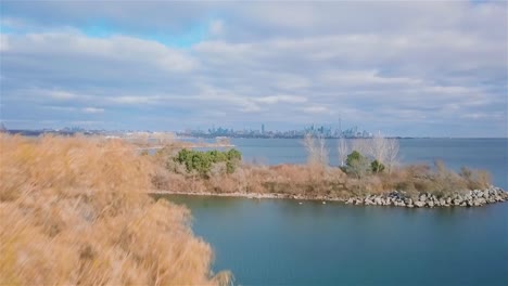 Toma-Aérea-Del-Lago-Y-La-Ciudad-En-El-Fondo