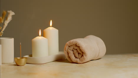 Still-Life-Of-Lit-Candles-With-Dried-Grasses-Incense-Stick-And-Soft-Towels-As-Part-Of-Relaxing-Spa-Day-Decor