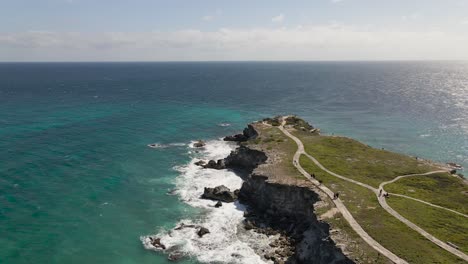 Antena-De-Acantilados-Rocosos-En-Un-Hermoso-Mar-Azul,-Isla-Mujeres,-México