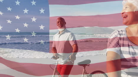 animación de la bandera de los estados unidos de américa sobre una feliz pareja de ancianos con bicicletas en la playa por el mar