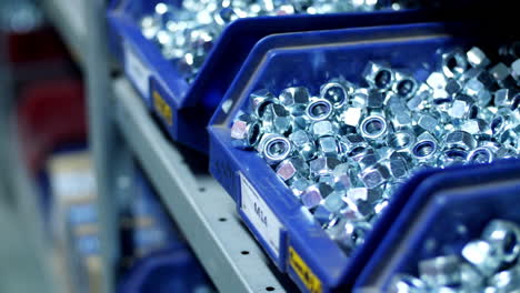 Pile-of-metal-stainless-steel-nuts-in-compartments-on-store-shelves