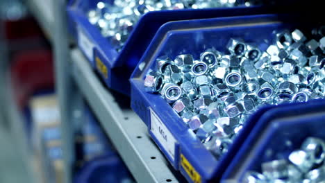 Pile of metal stainless steel nuts in compartments on store shelves
