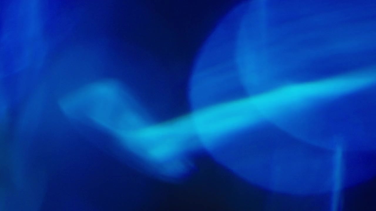 Raggi di luce blu astratti e tremolanti su sfondo nero