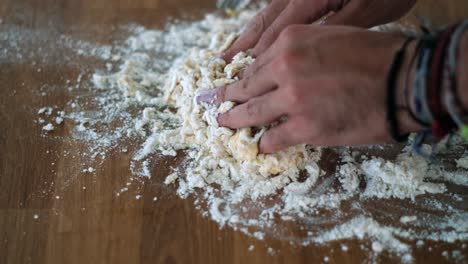 artisan breadmaking: senior chef's hands applying flour on dough - slow-mo closeup