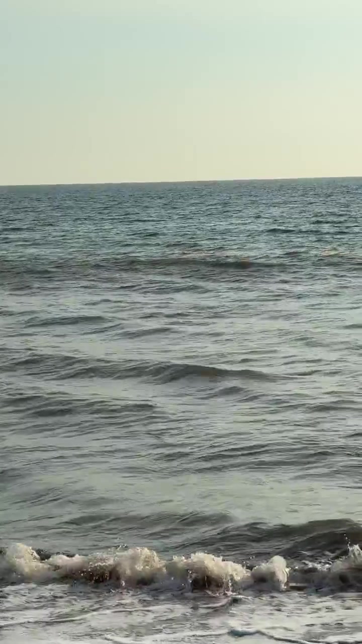 Onde calme dell'oceano che si infrangono dolcemente su una spiaggia sabbiosa
