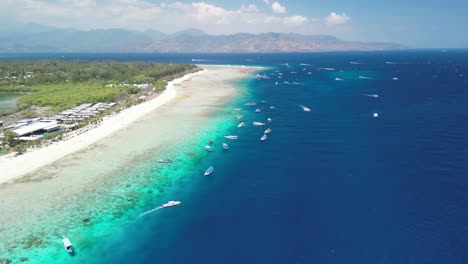 aerial panorama view of the beach at gili meno island, indonesia, in sunny weather and with plenty of boats in the crystal blue water