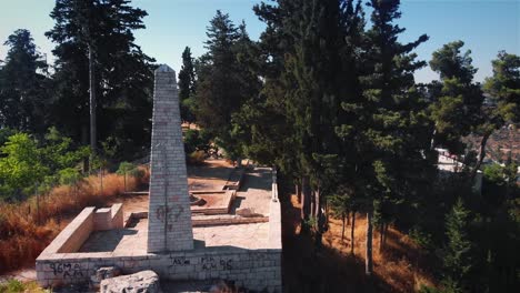 ancient stone obelisk and ruins in a forested park