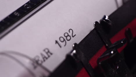 year 1982, typing on blank white paper in vintage typewriter, close up