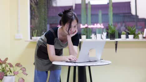 the restaurant manager is surfing the web . standing in a coffee cafe