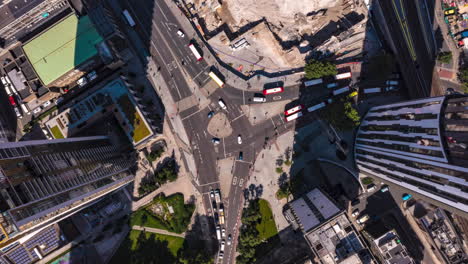 Aerial-birds-eye-overhead-top-down-descending-hyperlapse-footage-of-traffic-on-road-intersection-between-Elephant-and-Stata-tall-buildings-in-sunny-afternoon.-London,-UK