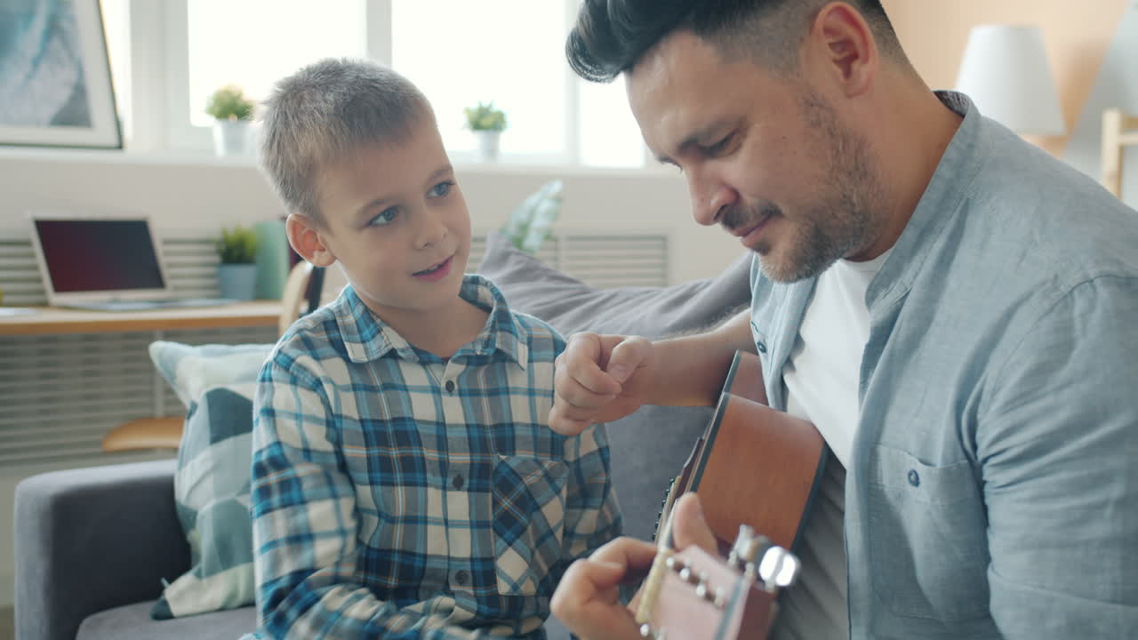 Padre enseñando a su hijo a tocar la guitarra
