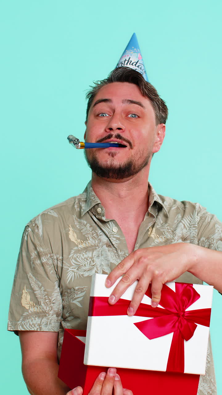 Man wearing party hat happily receiving longawaited birthday gift showing excitement and gratitude