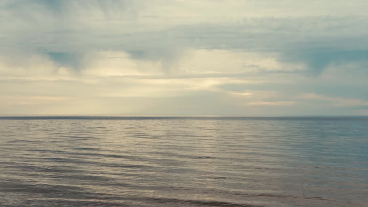 구름과 작은 파도가 있는 바다의 아름다운 일몰