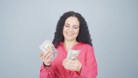 Young-woman-counting-money-looking-at-camera.