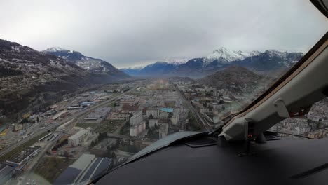 Jet-plane-approaches-over-city-and-lands-on-runway-in-Sion,-cockpit-view