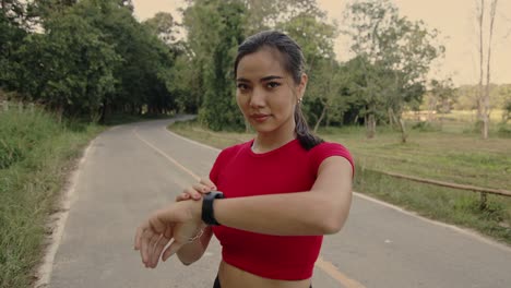 woman checking smartwatch on a country road
