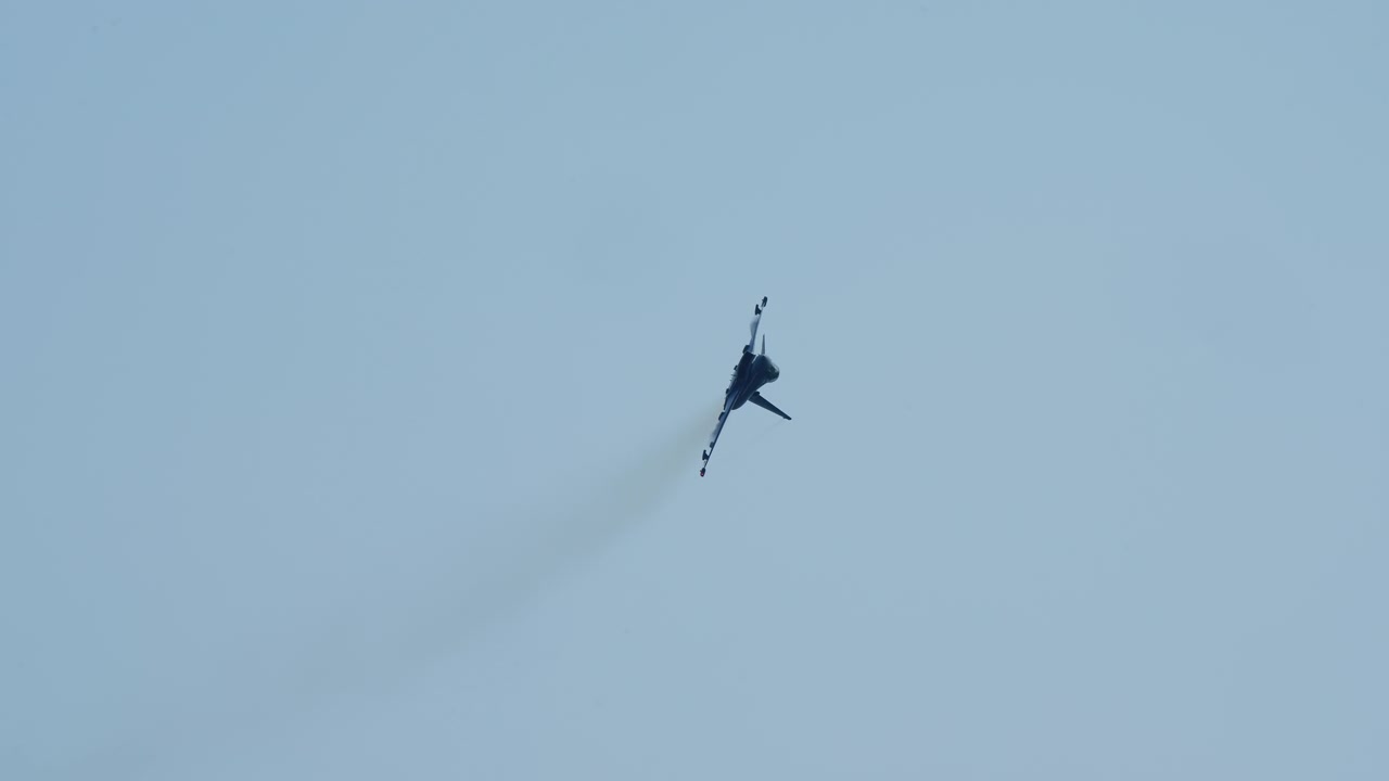 Military fighter jet flying through the sky and performing a sharp bank turn and climb, captured in slow motion as it rises higher in the air