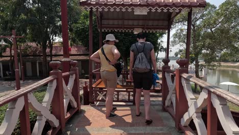 two people walking over a bridge in a park