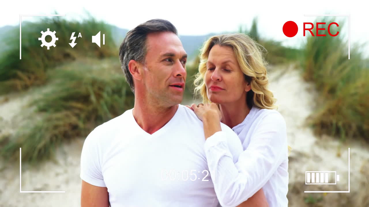 Recording animation over couple embracing on beach