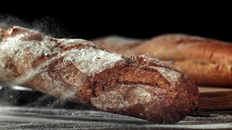 Slow Motion of Fresh Baguette Landing and Flour Dusting