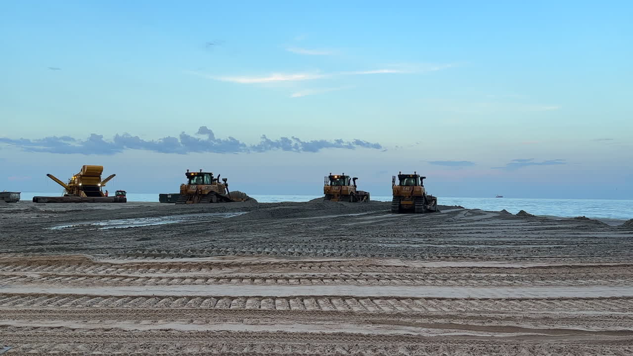 Eco-friendly beach sand replenishment, bulldozers leveling shoreline