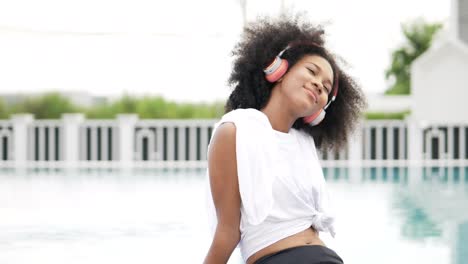 african woman in sportswear wearing headphones at swimming pool background . relaxing enjoys listening chill music . stock video