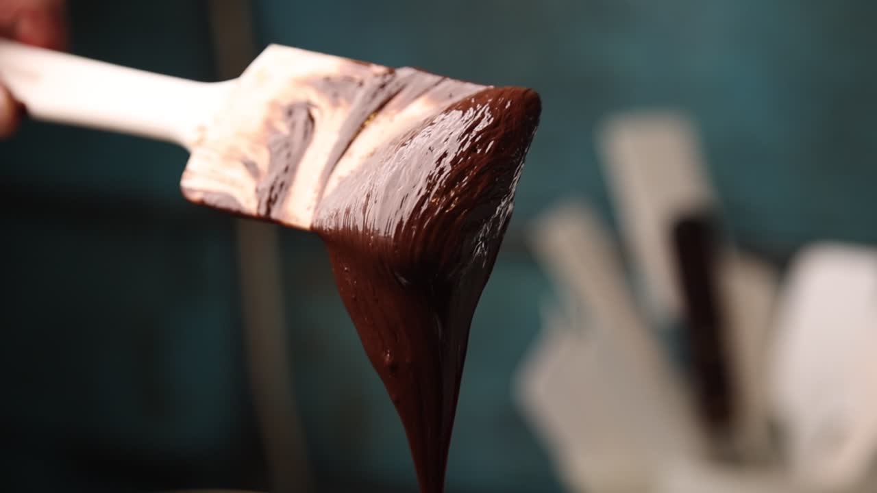 Cioccolato fuso che cola da una spatola