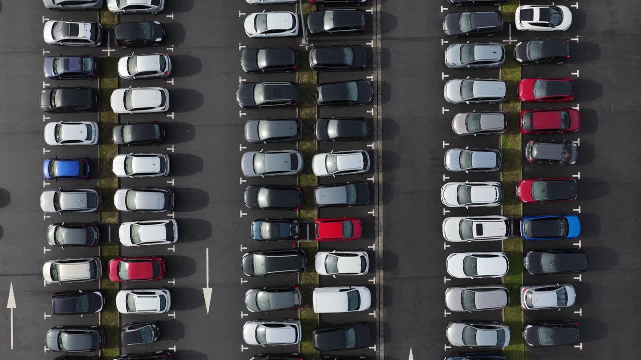 Droneoptagelse af parkeringsplads fyldt med biler, set ovenfra med drone.