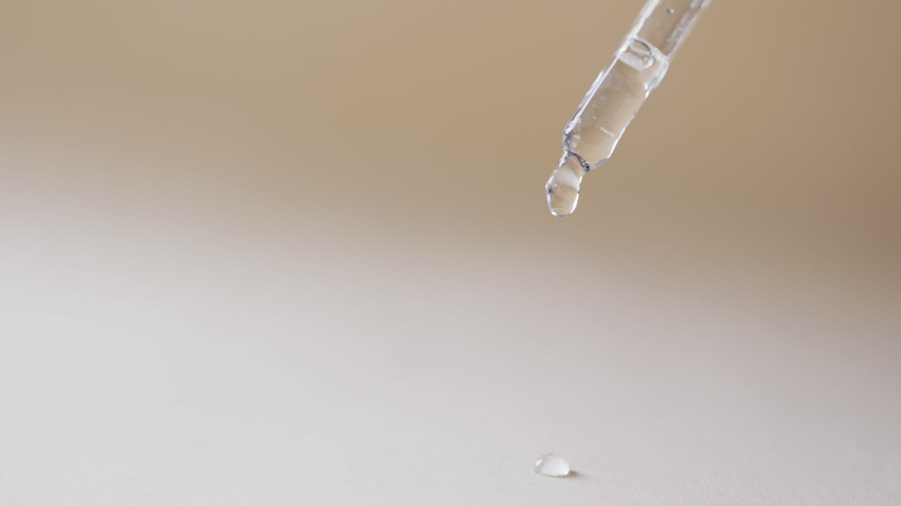 vídeo de la pipeta de maquillaje y las gotas de suero con espacio de copia en fondo marrón