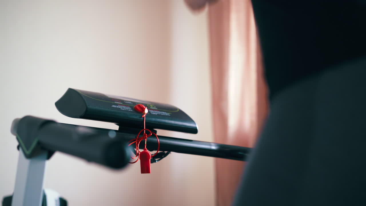 레 ⁇ 을 입은 여자가 트레드밀을 켜고 방에서 달린다.