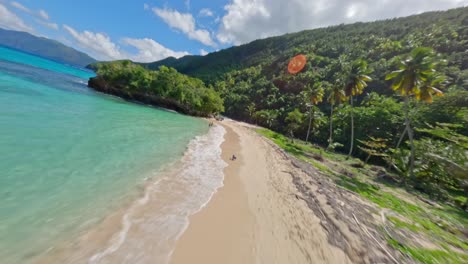 Speed-flight-over-tropical-beach-with-swimming-people-in-Caribbean-sea