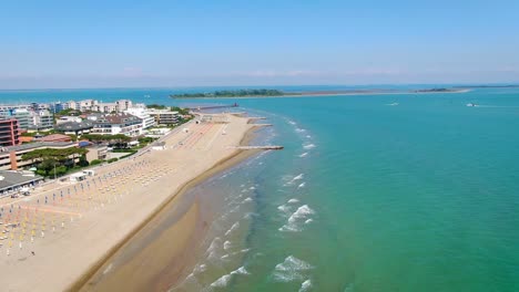 aerial view of the wide sandy beach with sun loungers and umbrellas on the coast of the italian peninsula lignano adriatic sea