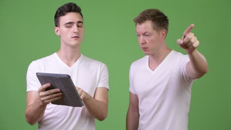 two young handsome men using digital tablet together