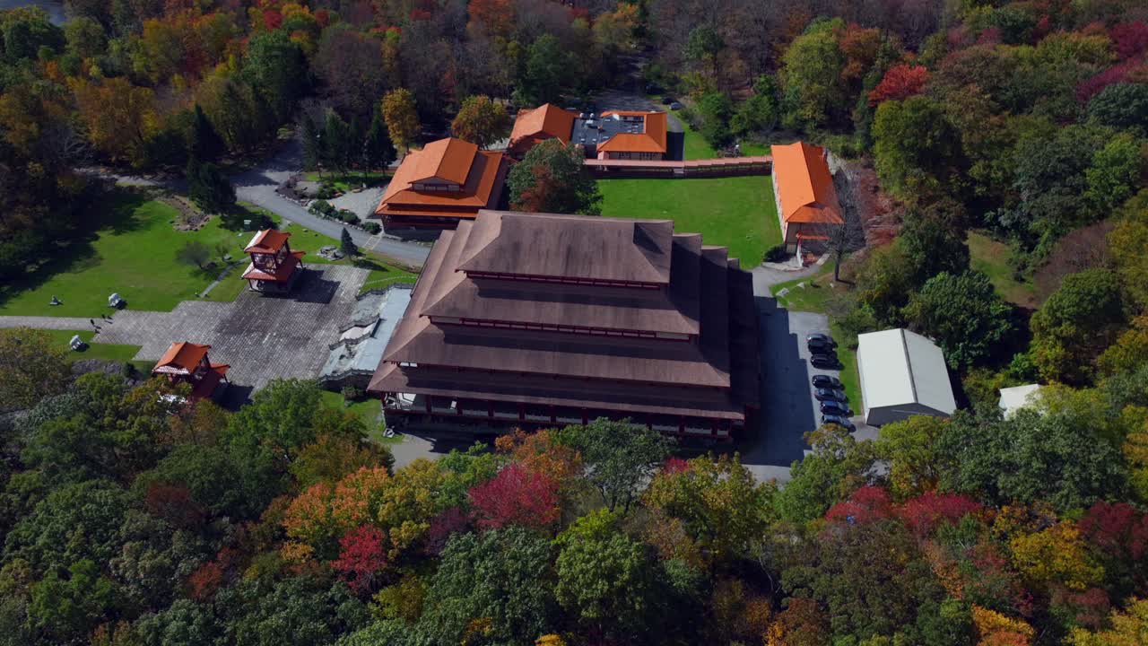 An aerial view of the Chuang Yen Monastery on a fall day, the leaves of the surrounding trees begin to change for the autumn season