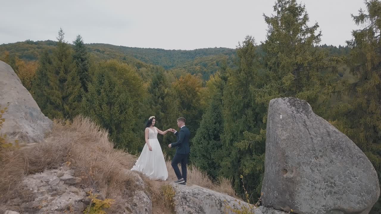 los recién casados están en una ladera alta de la montaña. el novio y la novia. vista aérea