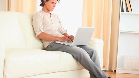 Man-sitting-on-a-sofa-searching-the-web