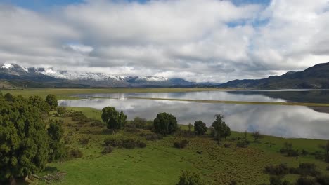 beautiful aerial of andes mountains a lake and pasture land near los alerces national park