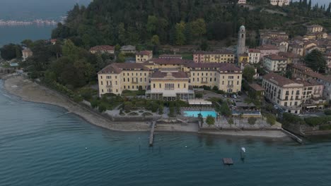 4k aerial - sunset slow pull back and reveal from hotel in bellagio lake como, italy