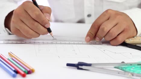 architect hands drawing lines using ruler and pencil on the paper