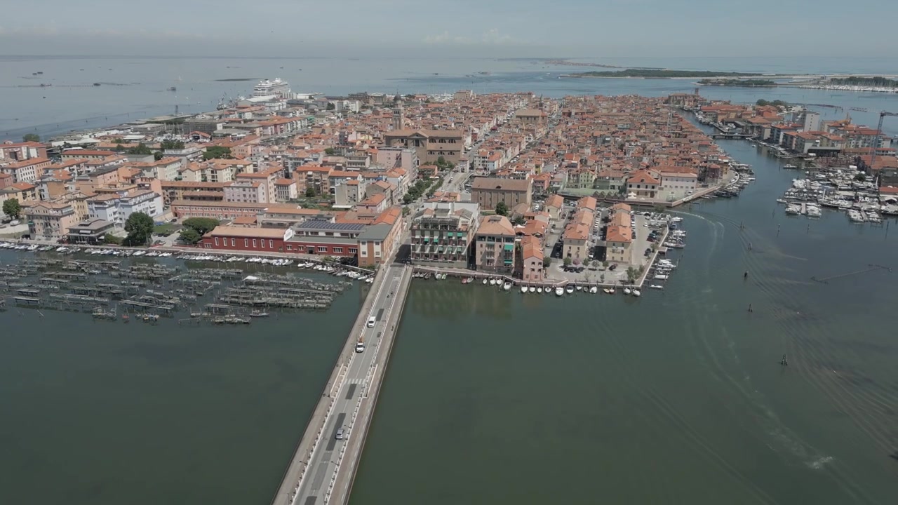Ripresa con drone del ponte di accesso principale alla città italiana di Chioggia in una giornata di sole