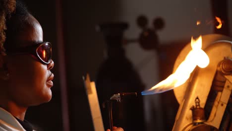 side view of black female worker creating glass in glass factory 4k