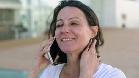 mujer hermosa sonriente hablando con el interlocutor a través del teléfono.